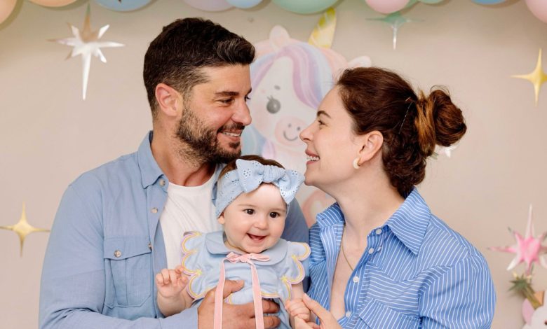 Berk Oktay kızı Mira Milenayı kucağında tutarken gülümserken çekilmiş bir fotoğraf